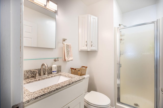 bathroom with vanity, toilet, and a shower with shower door