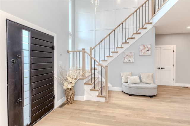 entrance foyer with light hardwood / wood-style floors and a high ceiling