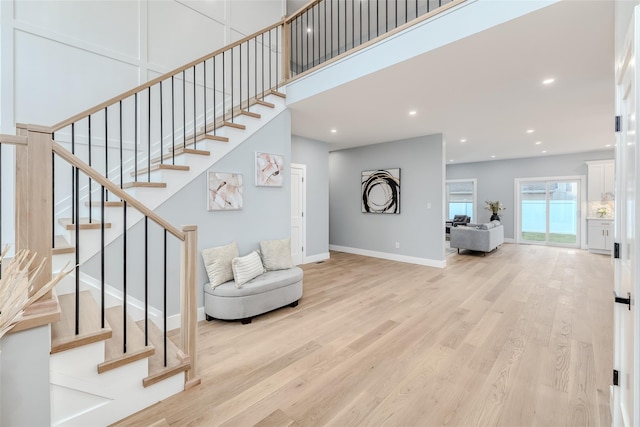 interior space featuring a towering ceiling and light hardwood / wood-style floors