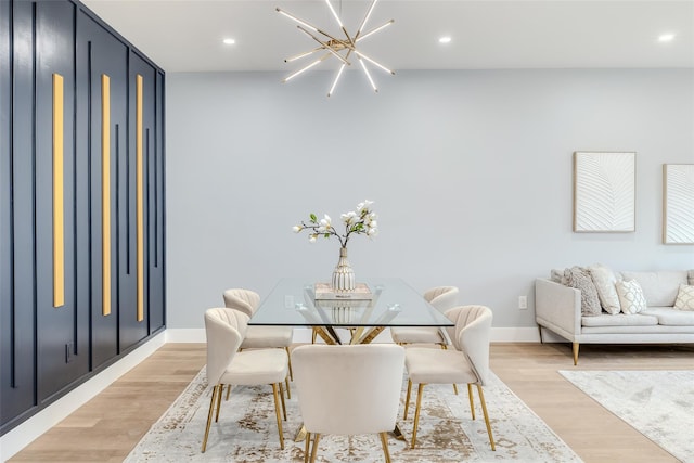 dining space with light hardwood / wood-style flooring and a notable chandelier