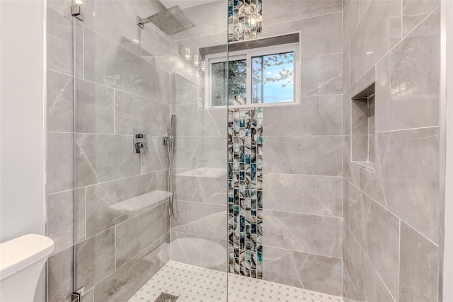 bathroom with tiled shower and toilet