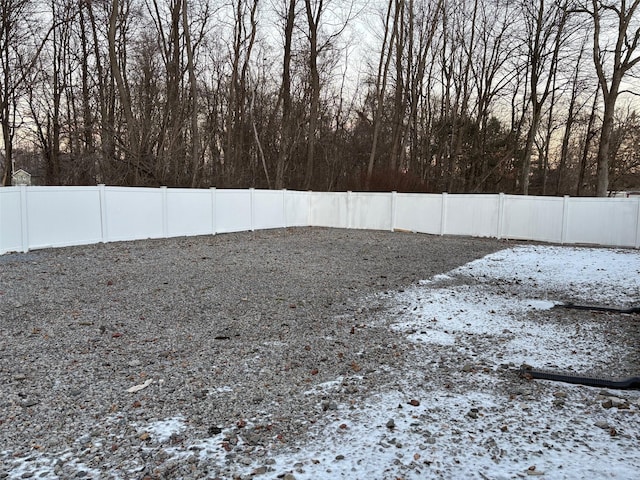 yard covered in snow with a fenced backyard