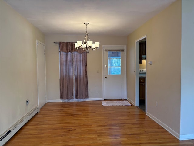 unfurnished dining area featuring light wood-style flooring, baseboards, baseboard heating, and a notable chandelier