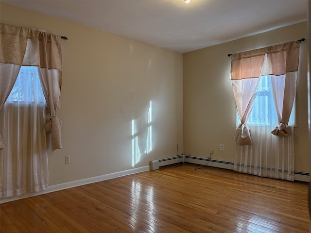 unfurnished room with baseboards and wood finished floors