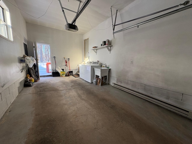 garage with a baseboard heating unit, a garage door opener, and washing machine and dryer