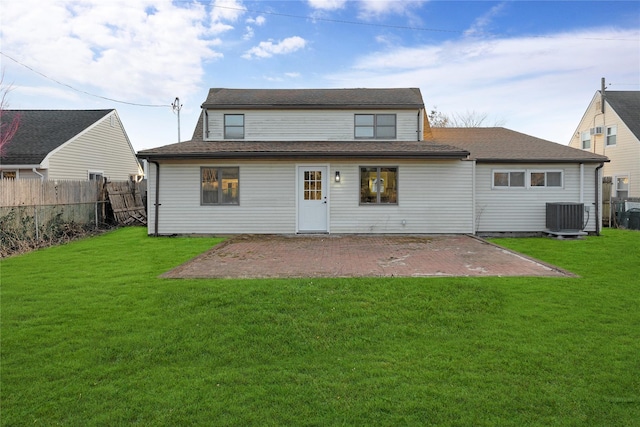 back of house featuring central AC unit, a patio area, and a lawn