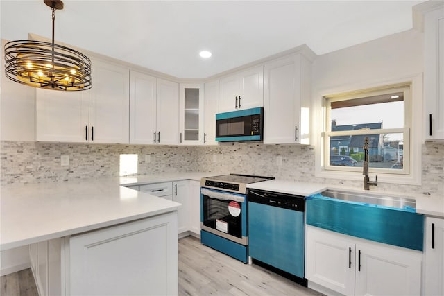 kitchen with light hardwood / wood-style flooring, appliances with stainless steel finishes, hanging light fixtures, tasteful backsplash, and white cabinets