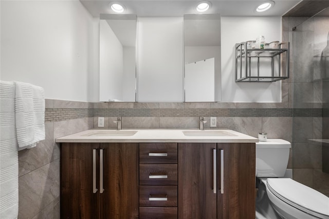 bathroom with vanity, toilet, and tile walls