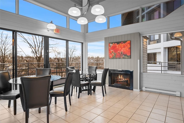 sunroom with a chandelier and a baseboard heating unit