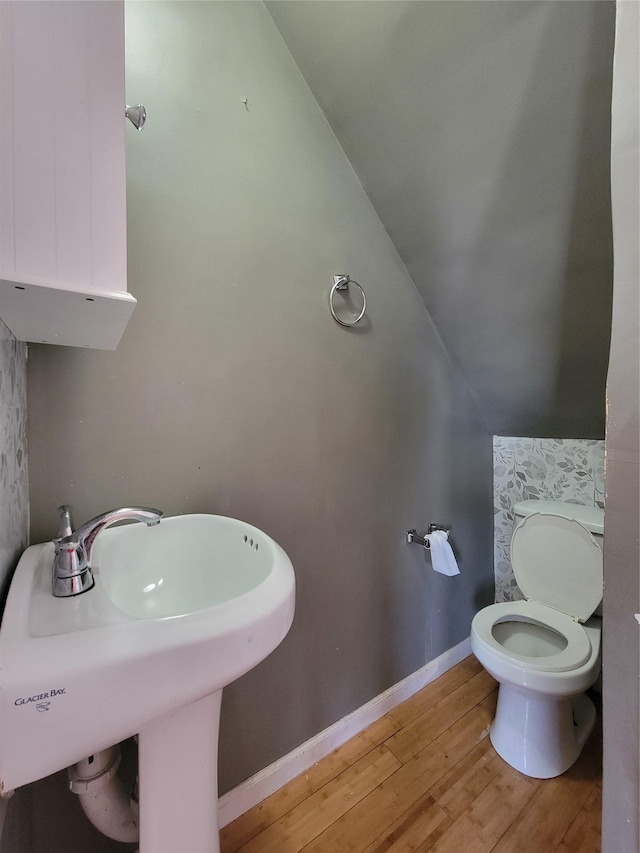 bathroom featuring vaulted ceiling, sink, toilet, and hardwood / wood-style floors