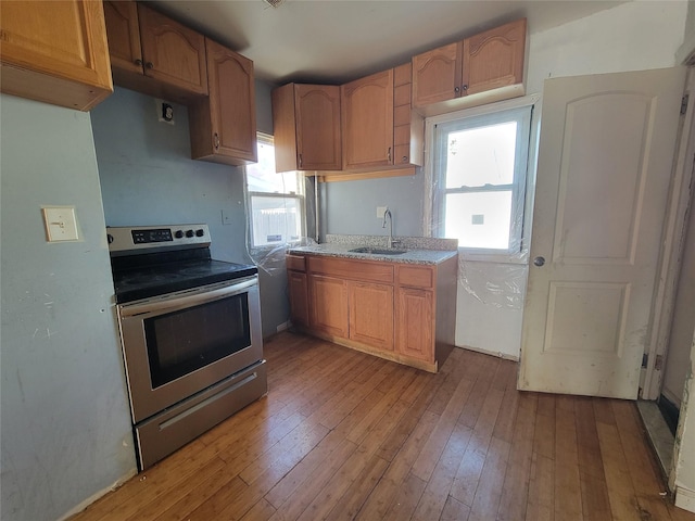 kitchen featuring sink, hardwood / wood-style floors, and electric range