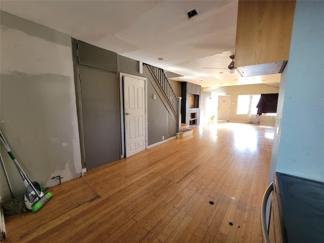 unfurnished living room featuring ceiling fan and light hardwood / wood-style floors