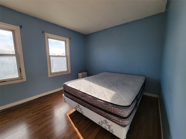 bedroom featuring dark wood-type flooring and radiator heating unit