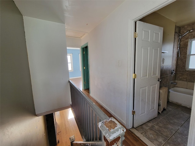 corridor featuring radiator heating unit and wood-type flooring