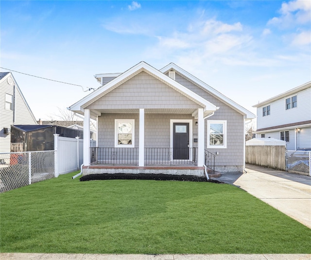 bungalow-style home with a front lawn and covered porch