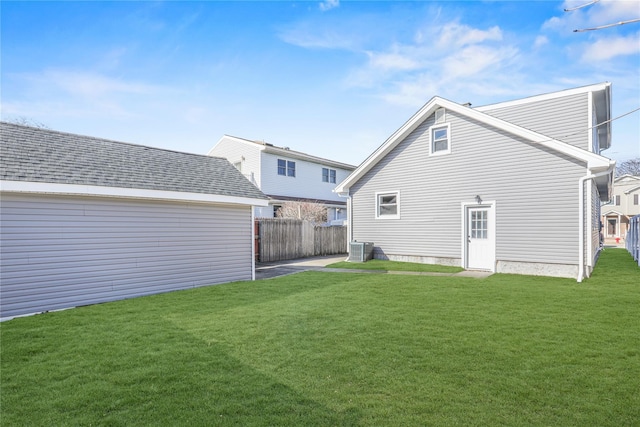 back of property featuring central AC unit and a lawn