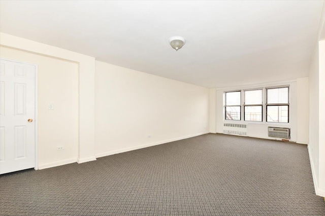 unfurnished room with radiator, a wall mounted air conditioner, and dark carpet