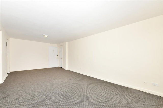 unfurnished room featuring dark carpet