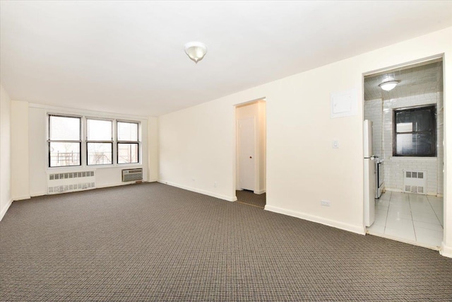 empty room with radiator and dark colored carpet