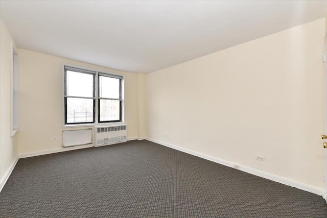 carpeted spare room with radiator heating unit