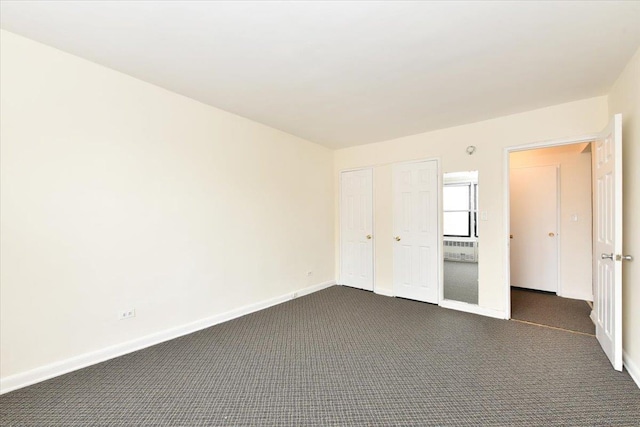 unfurnished bedroom featuring a closet and dark colored carpet