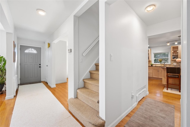 foyer entrance with sink and light hardwood / wood-style floors