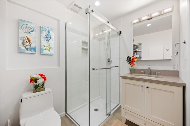 bathroom with vanity, toilet, and a shower with shower door