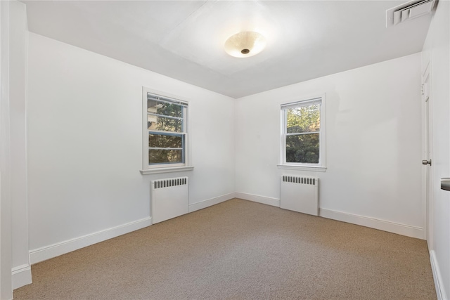 carpeted empty room featuring radiator