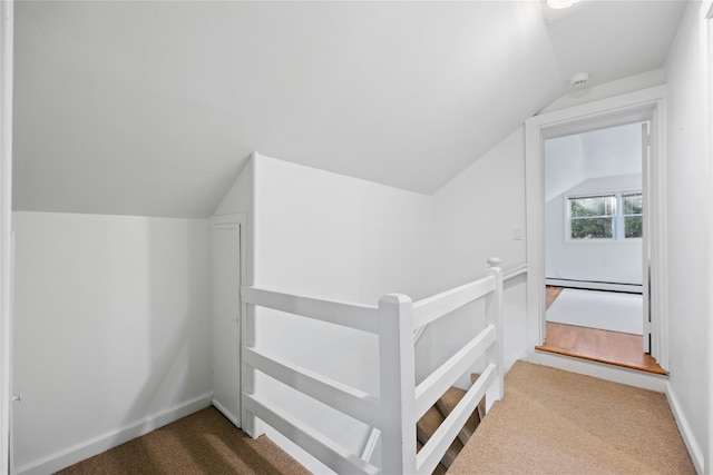 additional living space with a baseboard radiator, vaulted ceiling, and carpet flooring