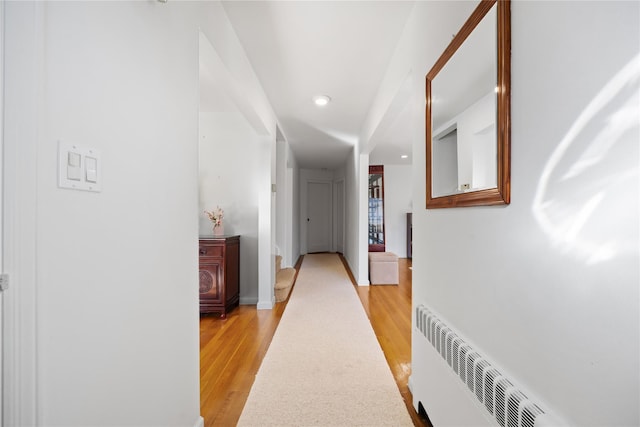 hall featuring radiator heating unit and light hardwood / wood-style floors