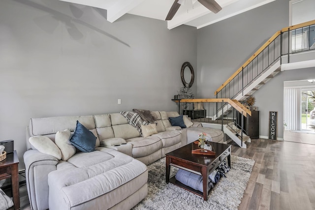 living room with beamed ceiling, a towering ceiling, hardwood / wood-style floors, and ceiling fan