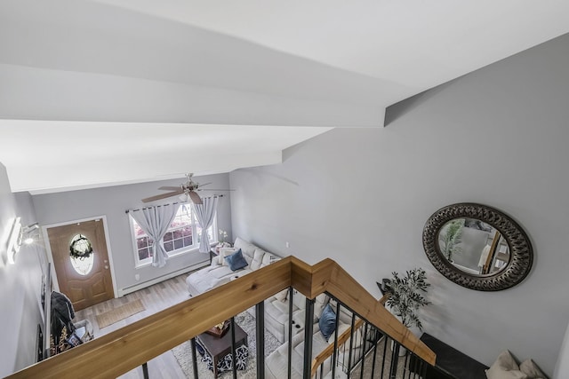 stairway featuring ceiling fan, lofted ceiling, and hardwood / wood-style floors