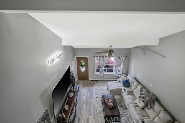 unfurnished living room with ceiling fan, wood-type flooring, a baseboard radiator, and vaulted ceiling