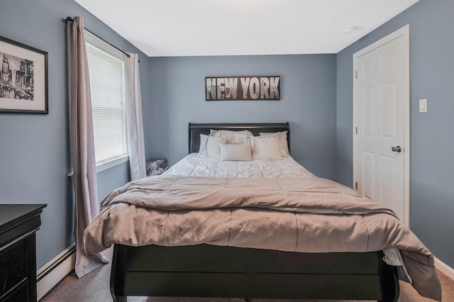 carpeted bedroom featuring a baseboard heating unit