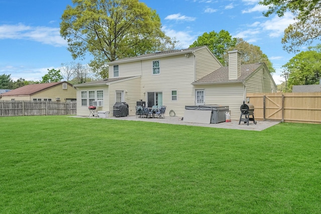 back of house with a patio area and a lawn