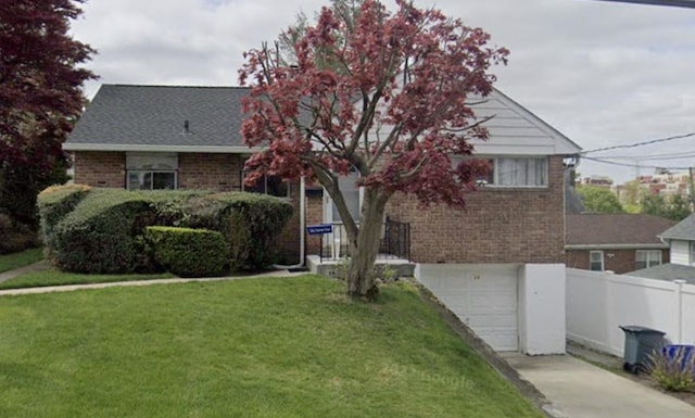 view of front of property with a garage and a front lawn