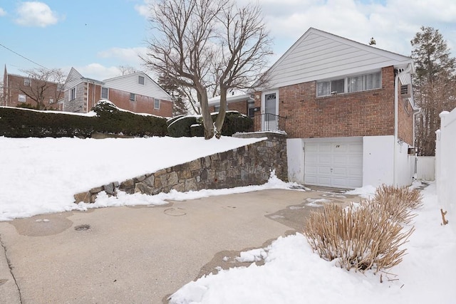 view of snow covered exterior with a garage