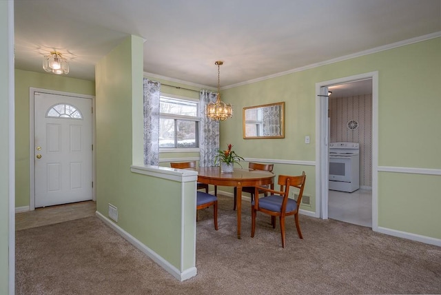 carpeted dining space featuring ornamental molding and a chandelier