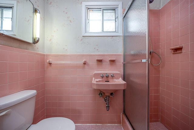 bathroom featuring tile walls, toilet, and walk in shower