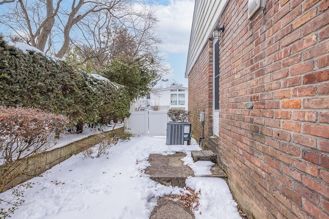 snowy yard featuring central AC unit