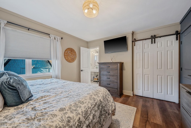 bedroom featuring dark hardwood / wood-style floors, a barn door, and a closet