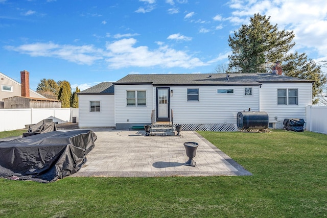 back of house with a patio and a lawn