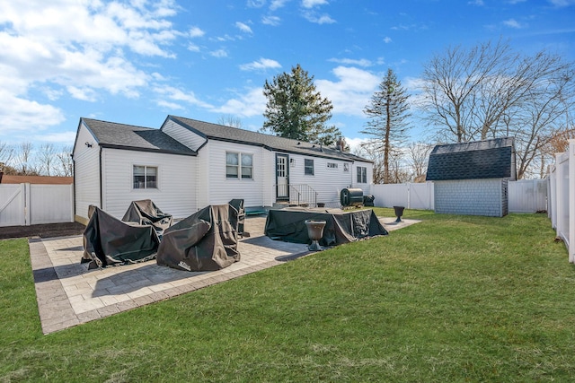 rear view of property with a yard, a shed, and a patio area