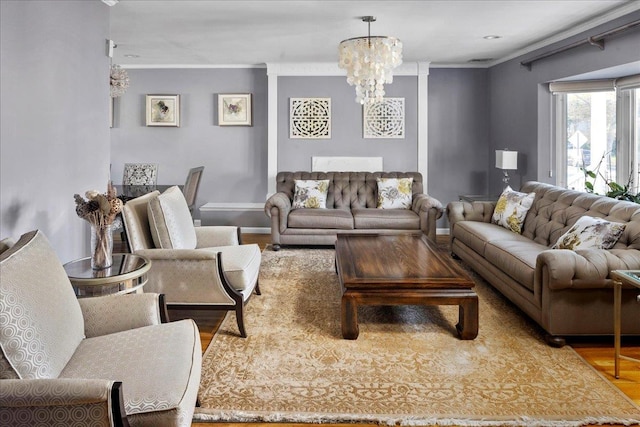 living room with hardwood / wood-style flooring, crown molding, and an inviting chandelier