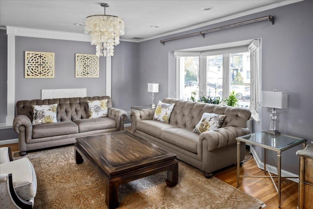 living room with an inviting chandelier, ornamental molding, and wood-type flooring