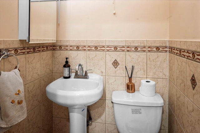 bathroom with tile walls and toilet