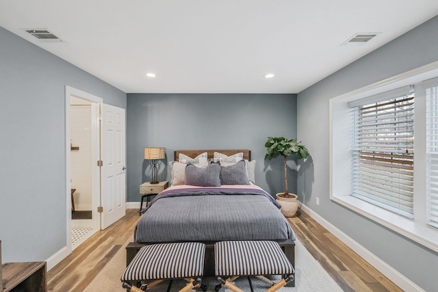 bedroom featuring ensuite bathroom and light wood-type flooring