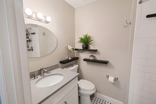 bathroom featuring vanity, toilet, and a tile shower