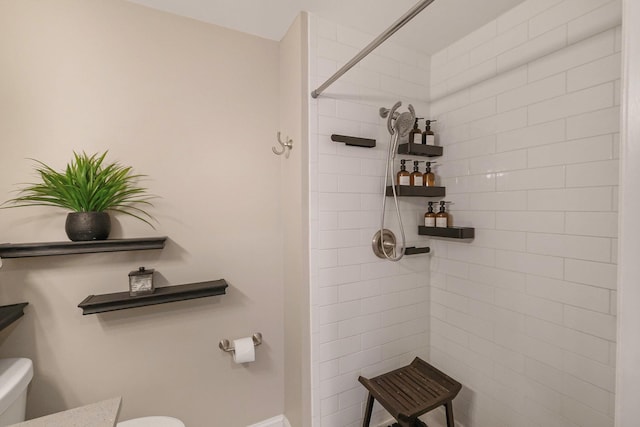 bathroom with tiled shower and toilet