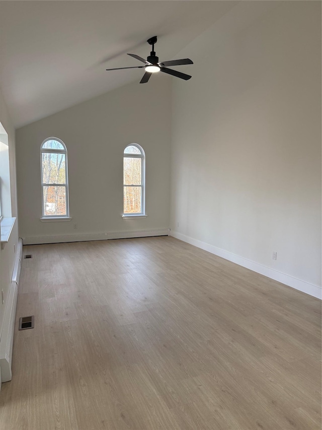 spare room with ceiling fan, high vaulted ceiling, light wood-type flooring, and a baseboard radiator